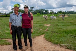 Photo of two farmers in a field with cattle 