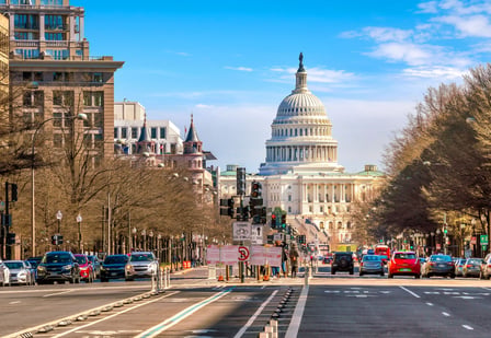 Washington DC Capitol building in background. Road with traffic in front.
