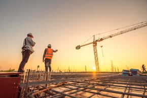 Construction workers pour concrete