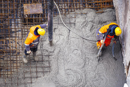 Image of two concrete workers standing on foundation