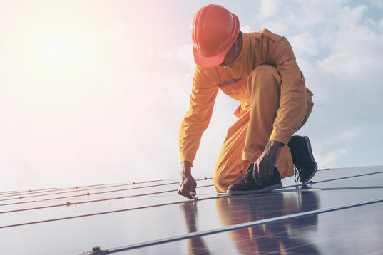 worker installing solar panels