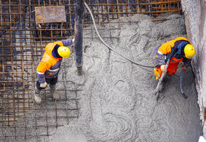 Concrete poured onto reinforced steel by workmen