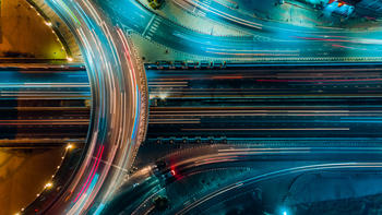 Aerial shot of a highway at night with blurred vehicles. 